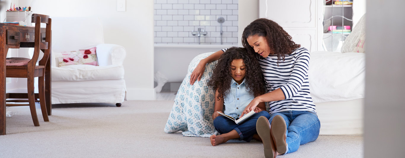 iStock-944580710-1366×534-M Mom and daughter reading by a bed